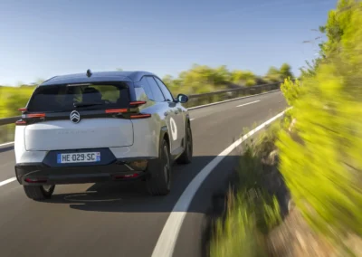 Citroen C5 Aircross, zdjęcie auta jadącego przez zakręt drogi między skałą a barierką, , widok na tył