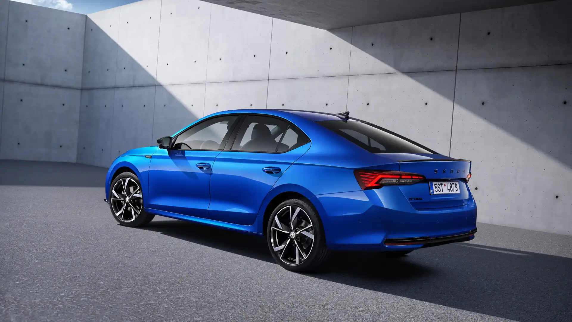 skoda_octavia_sportline_tech-4 Niebieska Skoda Octavia liftback w wersji Sportline Tech stojąca betonowym garażu, widok na tylną lewą część nadwozia