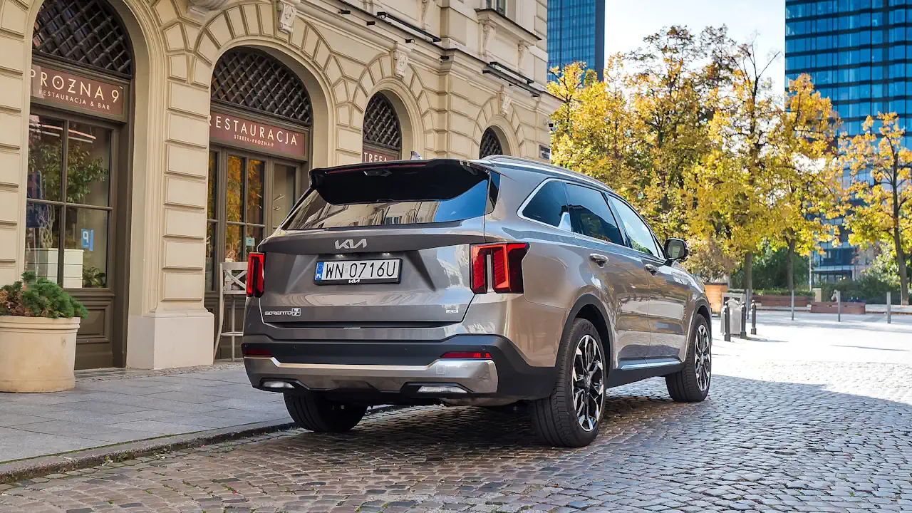 kia sorento adwert 13 Beżowa Kia Sorento stoi przed restauracją, widać tył i prawy bok samochodu