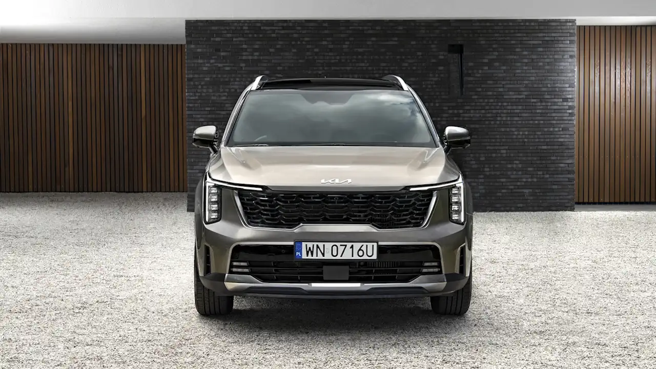 kia sorento adwert 26 Przód beżowej Kii Sorento stojącej przed nowoczesnym budynkiem