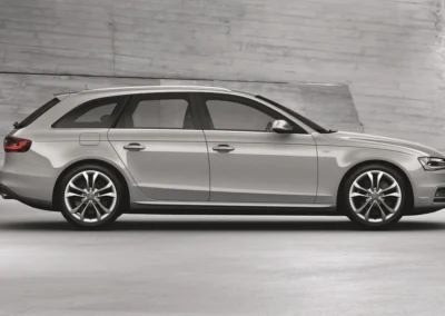 Prawy profil srebrnego Audi A4 B8 stojącego na tle betonowej ściany