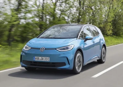 Niebieski Volkswagen ID.3 jedzie drogą, widać przód i lewy bok auta