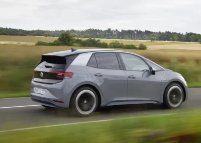 Szary Volkswagen ID.3 jedzie drogą, widać tył i prawy bok auta