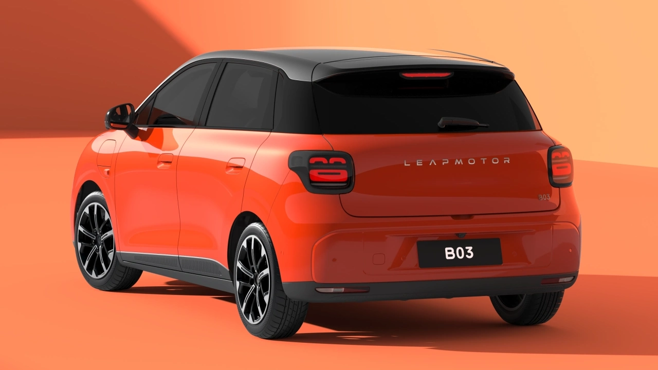 2026-Leapmotor-B03-06 Pomarańczowy Leapmotor B03 stoi w studiu fotograficznym na pomarańczowej podłodze – widać tył i lewy bok auta, w tle jest pomarańczowa ściana.