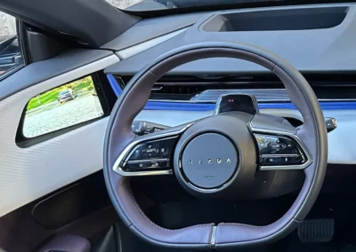 Mazda CX-6e – kierownica i wyświetlacz cyfrowego lusterka na drzwiach.