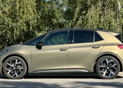Volkswagen ID.3 Neo stoi na brukowanej drodze – widać lewy bok auta, w tle są drzewa.
